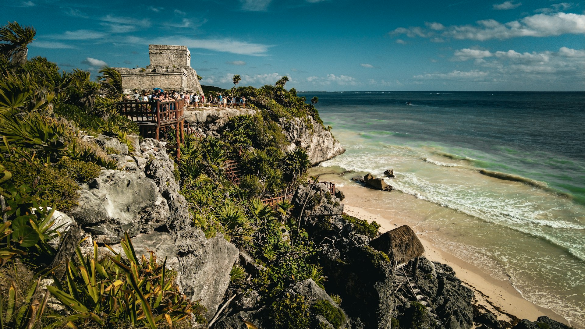 a group of people standing on top of a cliff next to the ocean